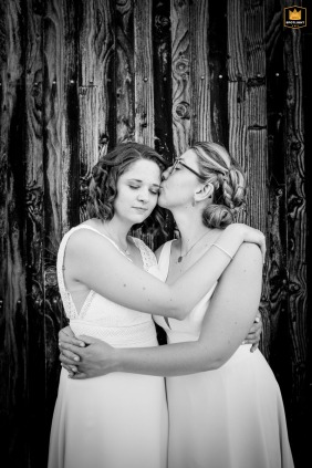 Jonzac, France, sweet embraces and a kiss on the head of a bride, capturing the tenderness of their wedding day portrait.
